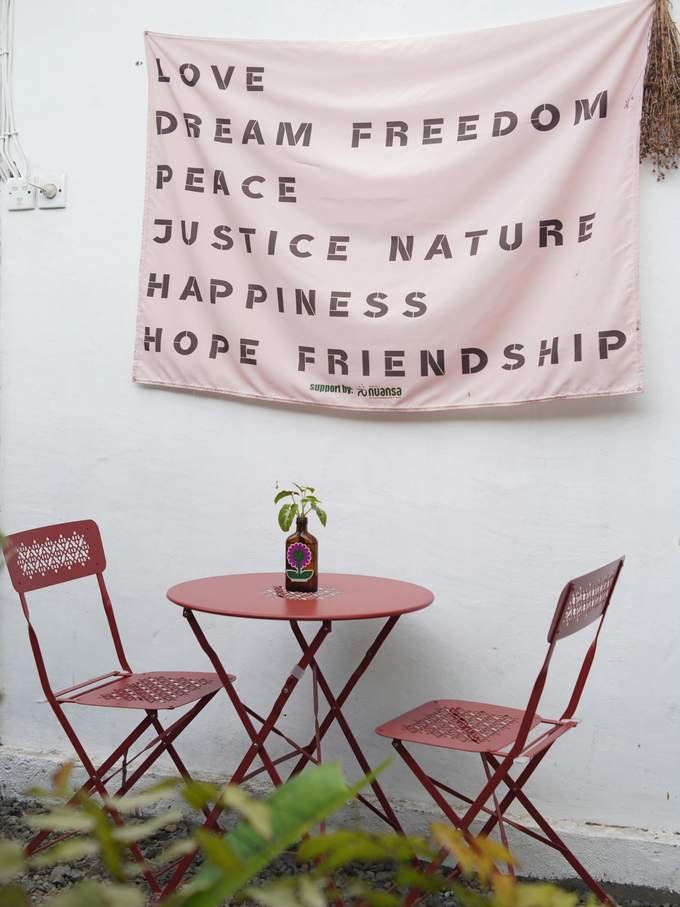 A red bistro table in front of a banner reading love, dream, freedom